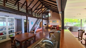Una cocina amplia con piso de madera, un comedor con mesa y sillas, y una escalera que conduce a un nivel superior.