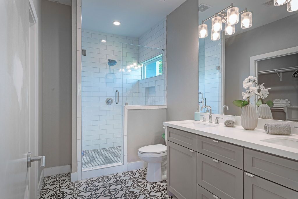 A modern bathroom with a shower, toilet, and vanity.