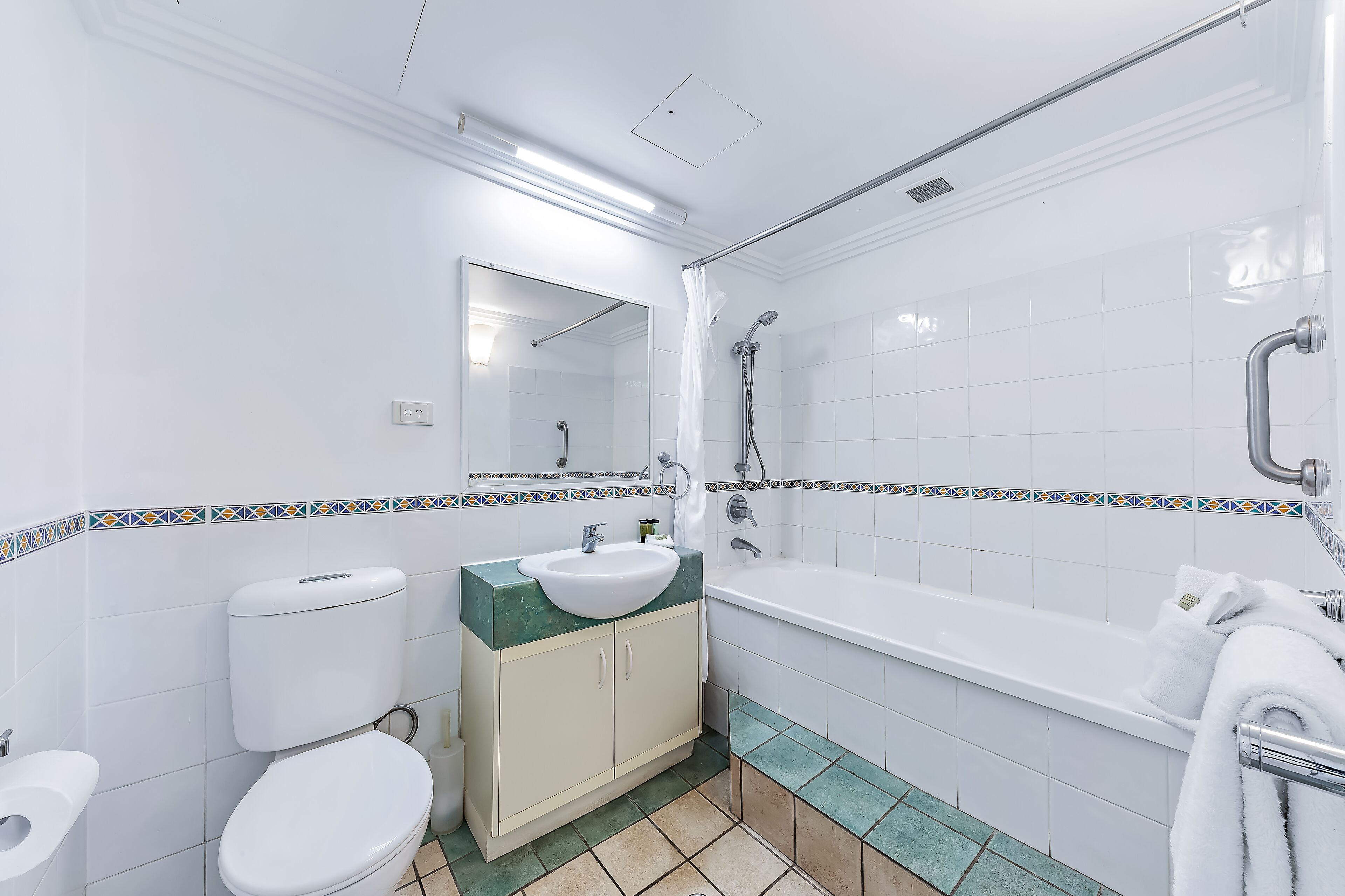 A modern bathroom with a toilet, sink, and bathtub.