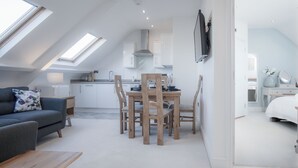 Een modern loft appartement met een eethoek, kitchenette en een slaapkamer.
