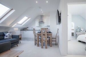 Eine moderne Loftswohnung mit Essbereich, Küchenzeile und Schlafzimmer.