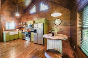 Une cuisine rustique avec des murs en bois, un îlot central et une table à manger.