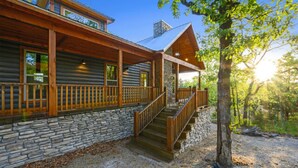 A log cabin with a stone foundation, wooden deck, and a stone chimney. - Fireplaces, hot tub, romantic cabin perfect for a honeymoon or a getaway for two (Ringold)