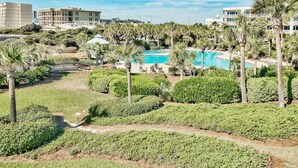 A resort with a swimming pool surrounded by palm trees and manicured lawns. - The Crescent unit 110 2BR Condo w/ FREE Beach Service! (Miramar Beach)