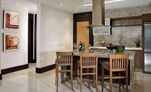 Enjoy cooking in this well-equipped kitchen with a central island, sink, and stainless steel range hood.