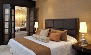 Relax in a spacious room with a large bed, nightstand, dresser, and mirror, plus a bathroom with a bathtub and vanity.