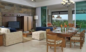 Relax in this stylish living room with a large flat-screen TV, comfortable sofa, and dining area.