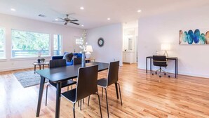 A spacious living area with a dining table, chairs, a sofa, and a ceiling fan. - 3BR Cozy Bungalow 1749! Medical Center, Stadiums! (Houston)