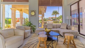 Un salón amplio con un ventanal grande, un sofá, una mesita de centro y un cuenco decorativo.