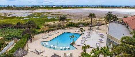 Un resort con piscina, playa y vista al océano.