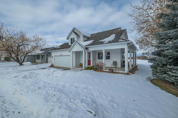 A two-story house with a covered porch and a garage. - Pet Friendly, Close to MSU, Downtown Bozeman w/ Mountain Views - Ravalli Street Retreat (Bozeman)