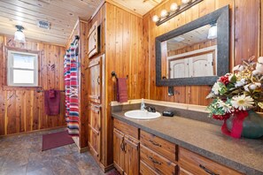 A wooden bathroom with a large mirror, a sink, and a vanity with drawers. - Game Room with pool table and ping pong, hot tub, less than a mile from lake (Ringold)