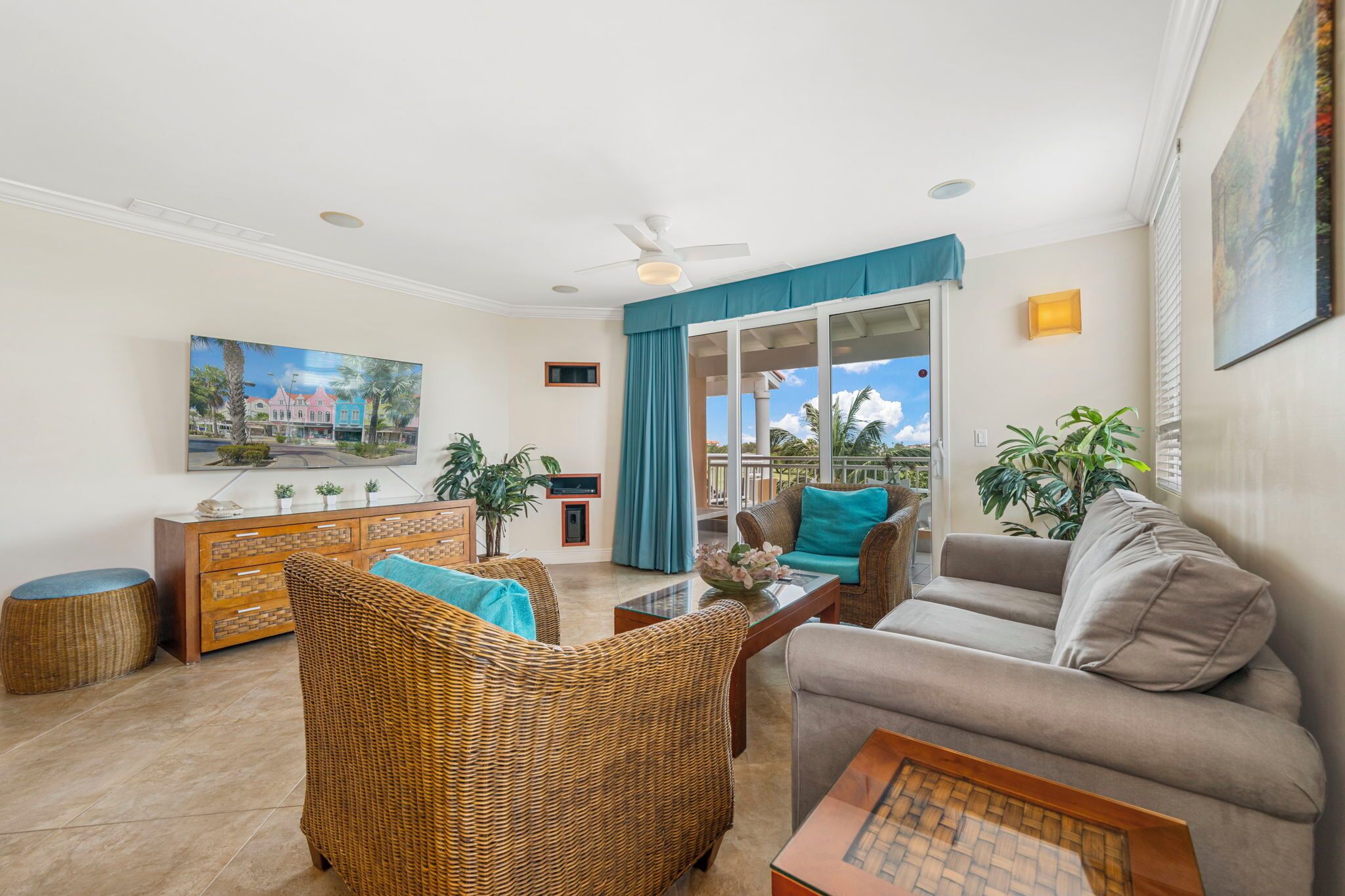 A living room with wicker furniture, a sofa, a coffee table, and a painting on the wall.