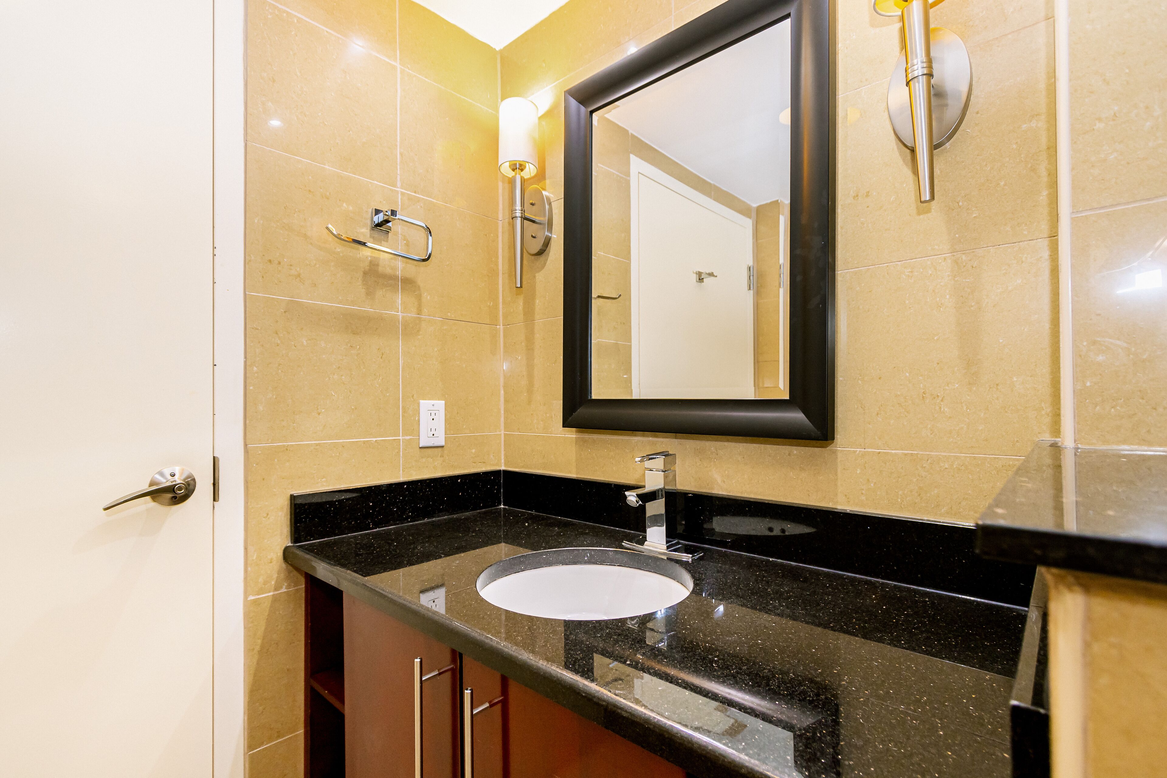 A bathroom with a sink, mirror, and towel rack.