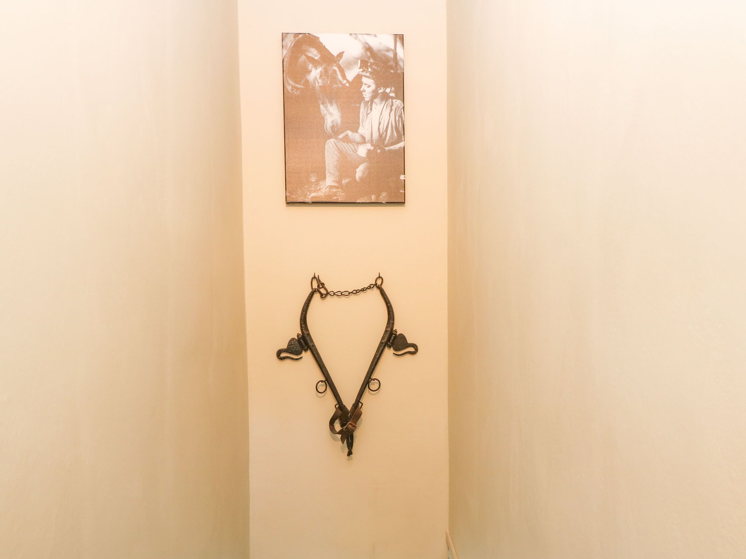 A wall with a vintage photograph and a metal object.