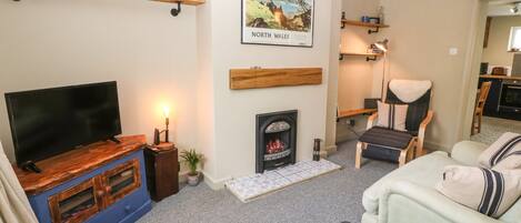 A cozy living room with a fireplace, a television, and a comfortable seating area.