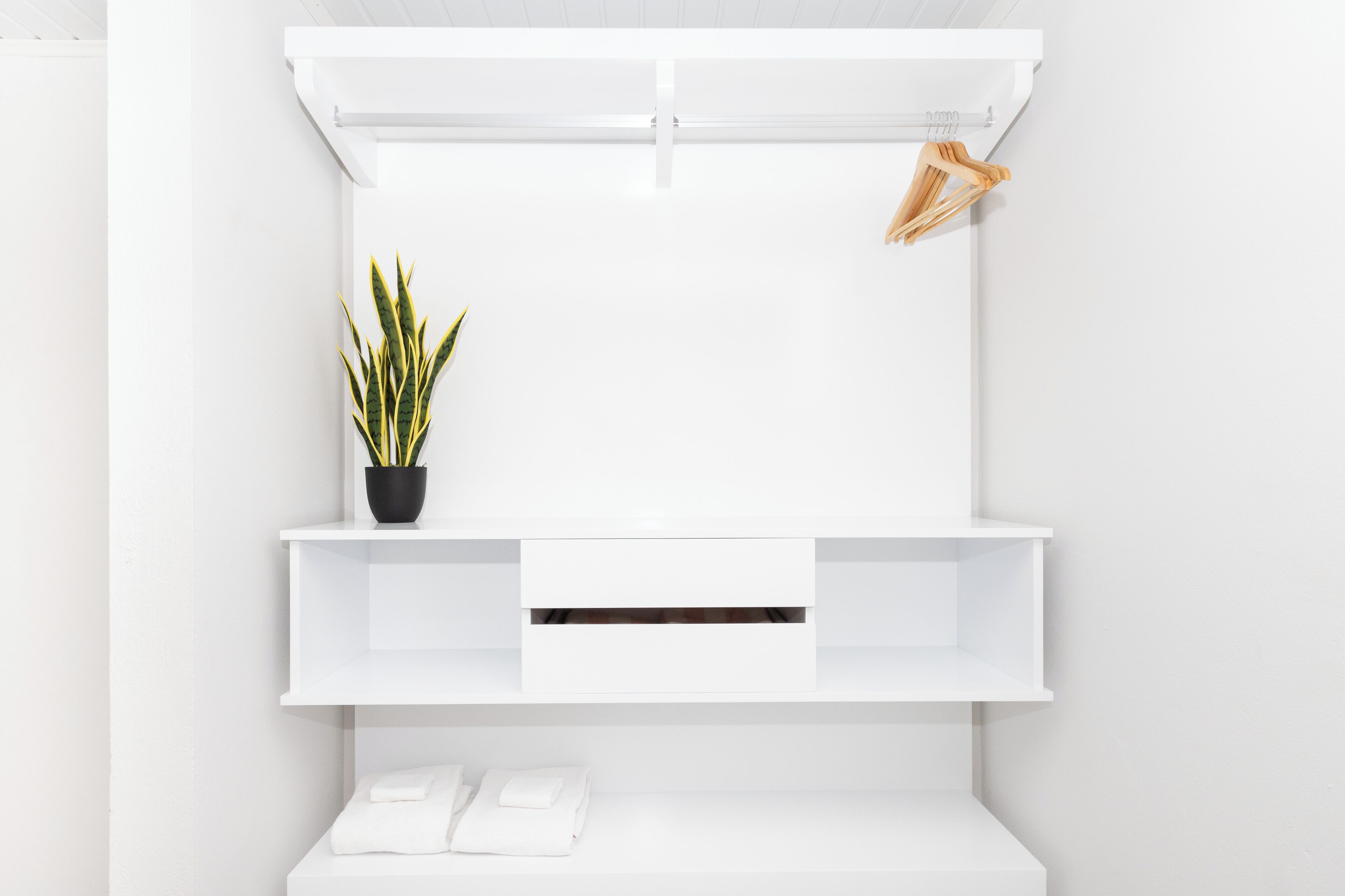 Una pared blanca con un mueble de estanterías empotrado.