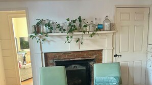 A living room with a fireplace, two armchairs, wooden flooring, and a white door. - Belfast Beauty - Downtown Belfast (Belfast)