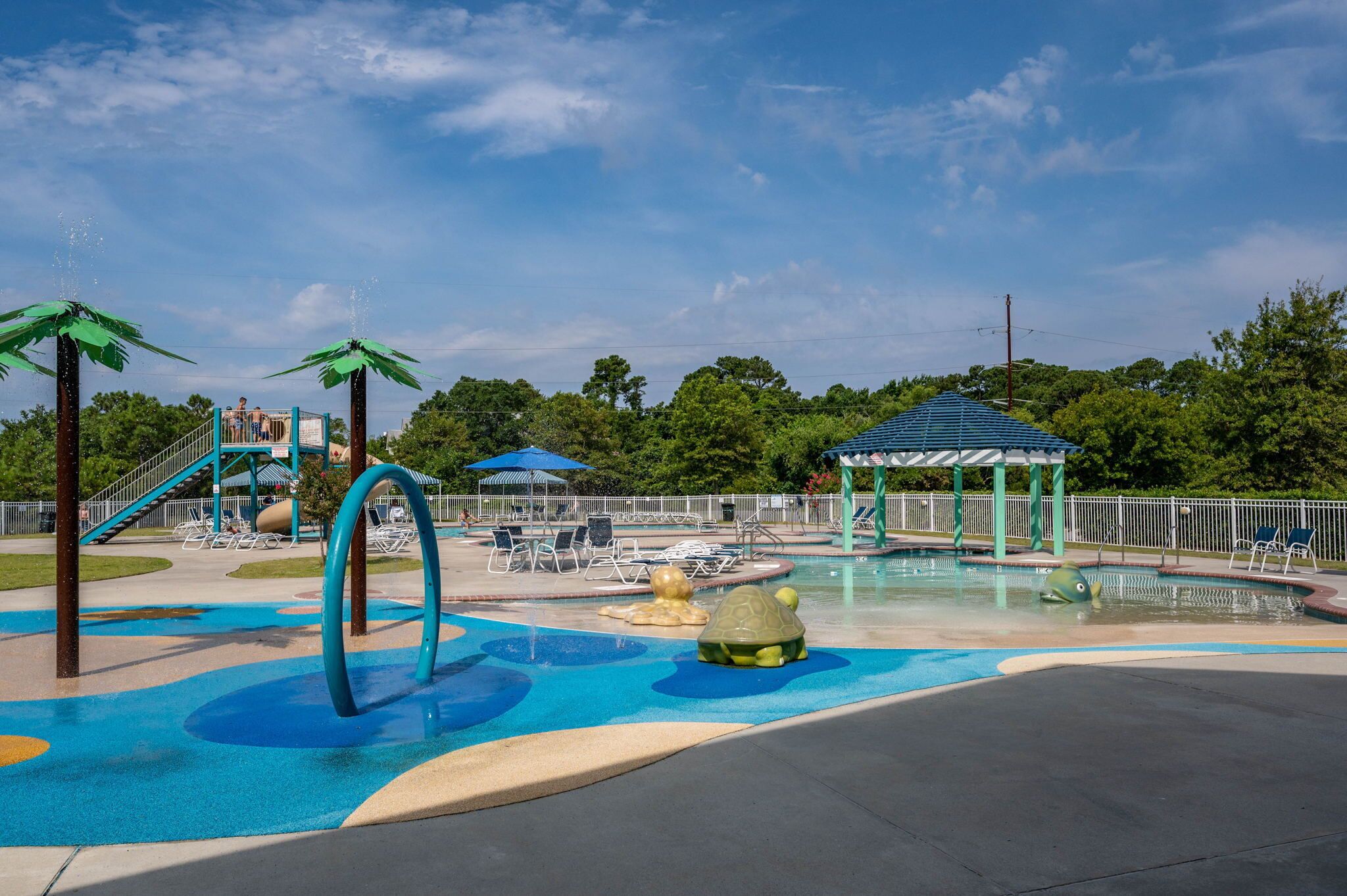 A playground with slides, a pool, and a gazebo.