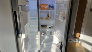 Un refrigerador abierto con diversos alimentos y bebidas.