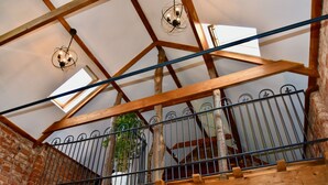 A wooden balcony with metal railings, a brick wall, and a hanging light fixture. - 2-Bed 18th Century Barn - Sleeps 6 - Pet Friendly (Boston)