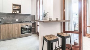 Une cuisine moderne avec des meubles en bois, un four encastré et une grande fenêtre.