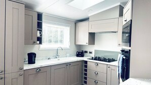 A modern kitchen with a window, built-in cabinets, a sink, and a stove.