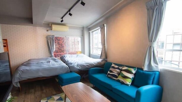 A compact hotel room with a bed, a sofa, a small table, and a window with curtains. - SHATOREYOYOGI401 (Tokyo)