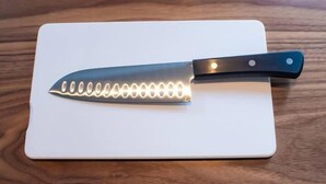 A knife with a black handle and a white cutting board. - SHATOREYOYOGI401 (Tokyo)