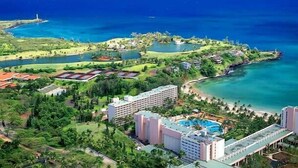 A resort with multiple buildings, a swimming pool, and a view of the ocean. - Kauai | Kauai Beach Escape | Pool & Beach (Kauai)