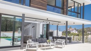 A modern outdoor living area with a sofa, chairs, and a dining table. - Protaras Elite Pearl Villa EP14 -  a villa that sleeps 11 guests  in 5 bedrooms (Protaras)