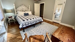 A bedroom with a bed, a nightstand, a chair, a ceiling fan, and a door. - Classy home w/ deck & fenced yard only 2 blocks from the fairgrounds!! (Tulsa)