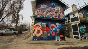 Un bâtiment orné d’une fresque colorée représentant de grandes lettres et un visage de style dessin animé.