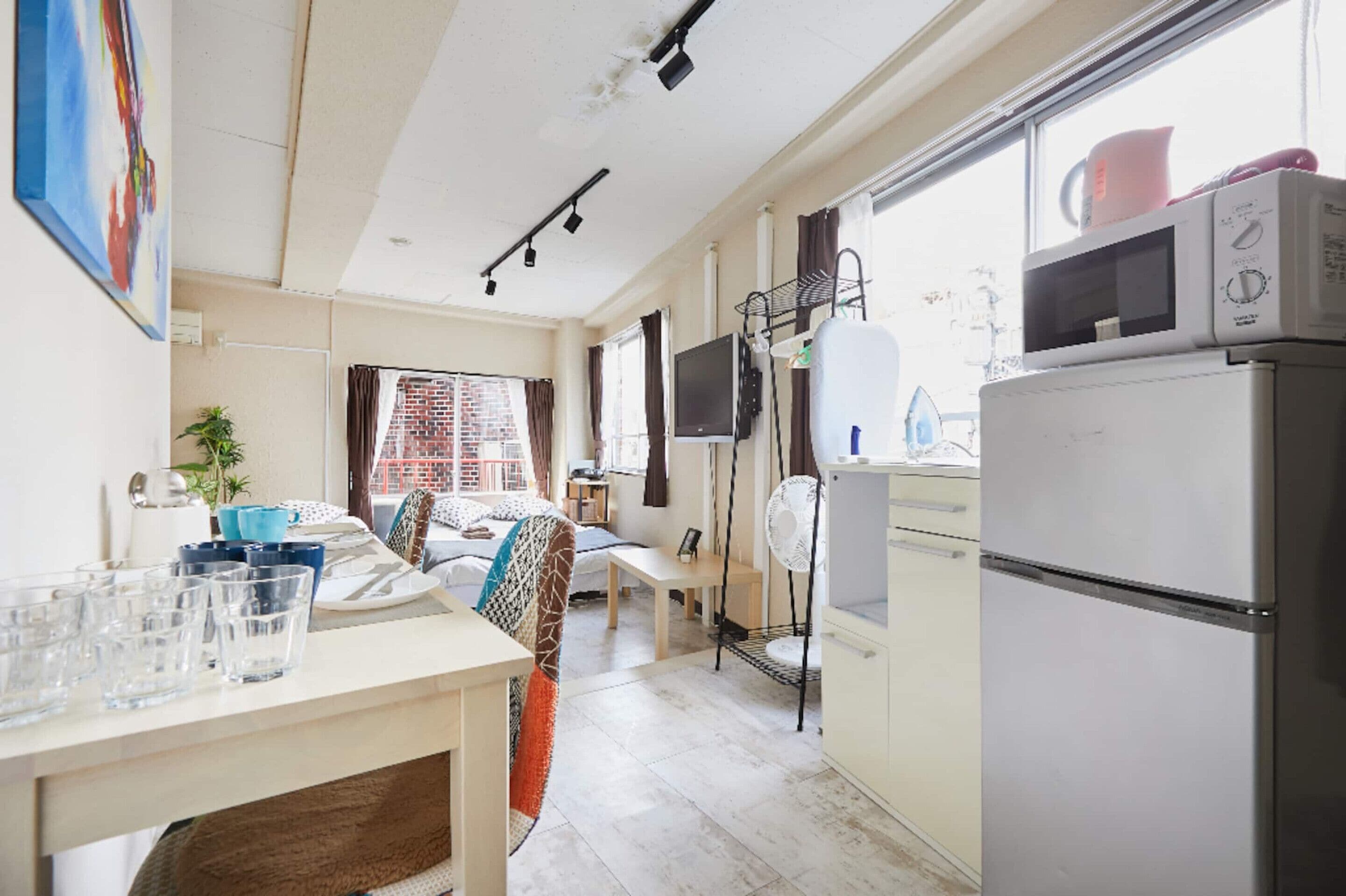 Une cuisine compacte équipée d’un réfrigérateur, d’un four à micro-ondes et d’un coin repas avec une table et des chaises.