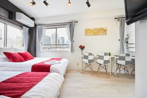 A hotel room with two beds, a desk with chairs, a TV, and a view of the cityscape. - SHATOREYOYOGI (Tokyo)