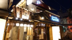 A traditional Japanese building with a neon sign, wooden decorations, and a signboard with Japanese characters. - SHATOREYOYOGI (Tokyo)