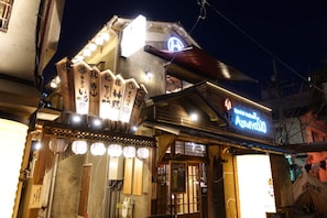 A traditional Japanese building with a neon sign, wooden decorations, and a signboard with Japanese characters. - SHATOREYOYOGI (Tokyo)