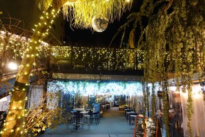 An outdoor dining area with string lights, tables, and chairs, under a covered section labeled 'Stella by Starlight.' - SHATOREYOYOGI (Tokyo)