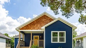 A two-story house with a wooden front porch, a blue exterior, and a number '1751' on the door. - 3BR Great Bungalow 1751! Medical Center, Stadiums! (Houston)