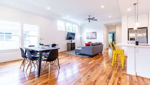 A spacious living area with a dining table, sofa, and yellow chairs. - 3BR Great Bungalow 1751! Medical Center, Stadiums! (Houston)