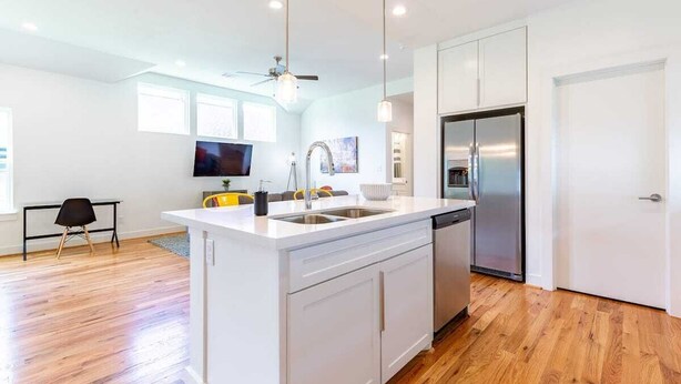 A modern kitchen with white cabinetry, a stainless steel refrigerator, and a built-in dishwasher. - 3BR Great Bungalow 1751! Medical Center, Stadiums! (Houston)