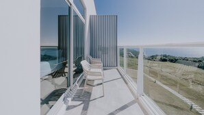 En moderne balkon med frit udsyn over landskabet, med en trappebaseret siddeplads og gelænder af glas.