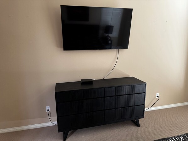 A black entertainment center with a flat-screen TV mounted above it.