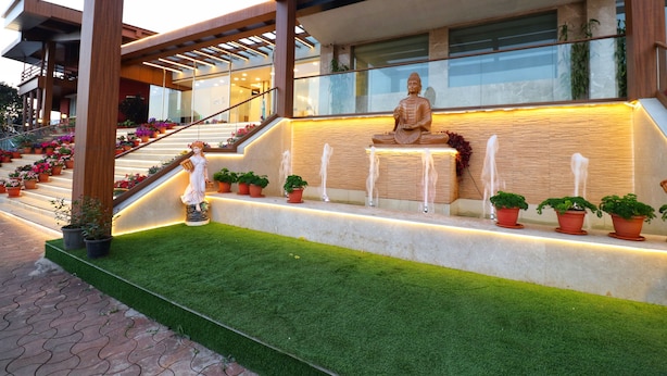 Un edificio moderno con una estatua de Buda, una escalera y plantas en macetas.