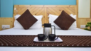 A neatly made bed with two pillows, a tray with two mugs and a coffee pot, and a polka dot blanket. - Madhuvan 2BHK, W/ Food, parking, Mountain View (Manali)