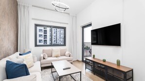 Een moderne woonkamer met een bank, salontafel en televisie.