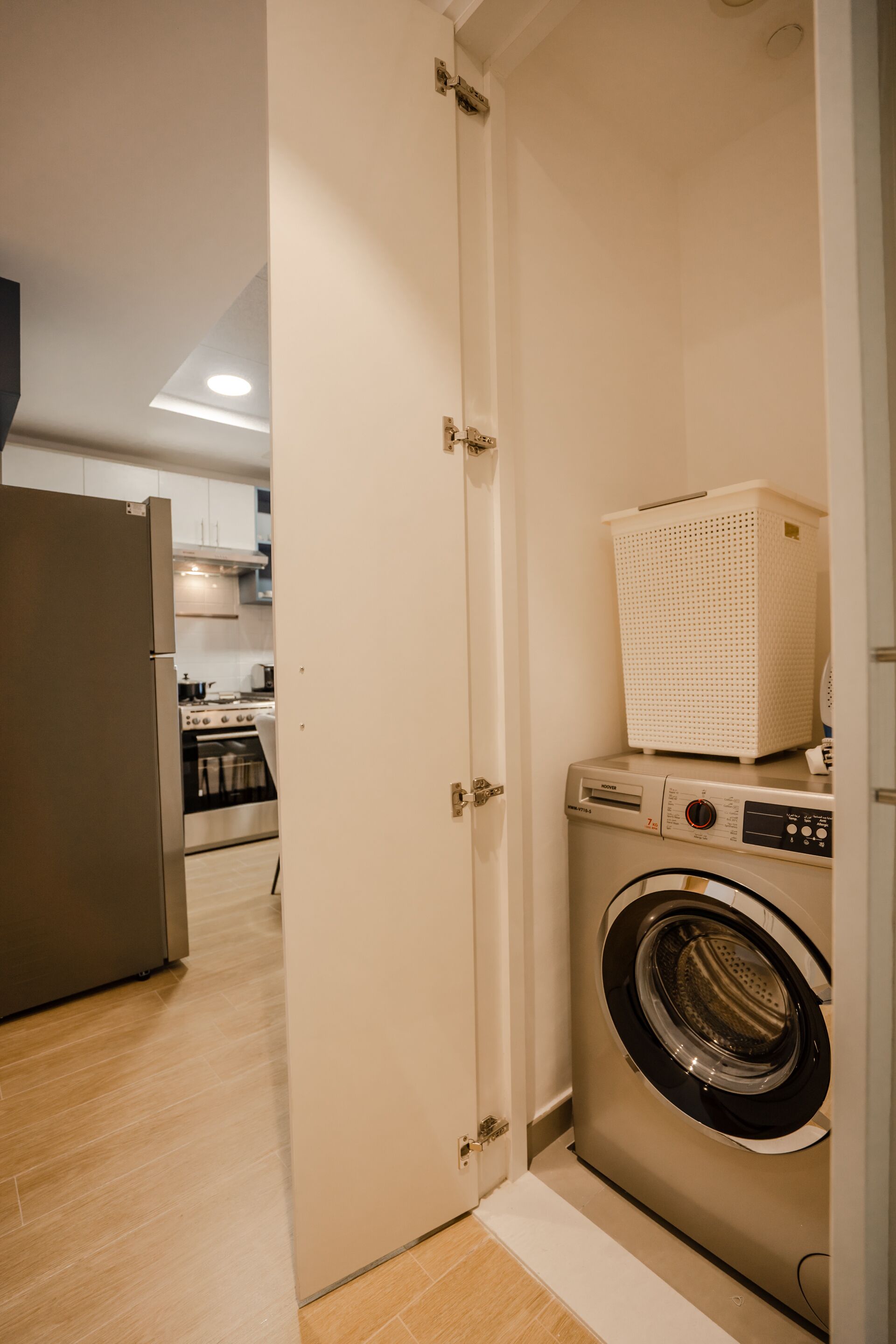 Une buanderie avec un lave-linge et un panier posé sur le dessus.