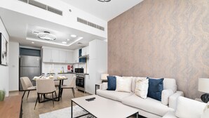 Een moderne woonkamer met een bank, salontafel en een eethoek.