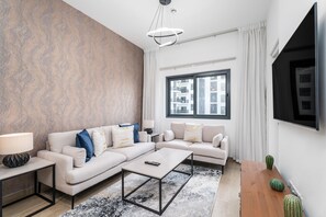 Apartamento Deluxe | Zona de estar | Smart TV de 55 pulgadas con canales por cable, una televisión