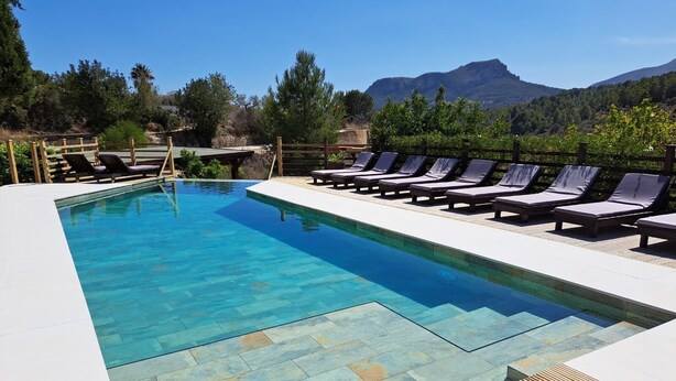 A rectangular swimming pool with clear blue water, surrounded by lounge chairs and a wooden deck. - Oltavista 10 pax - Benissa, Costa Blanca (Benissa)